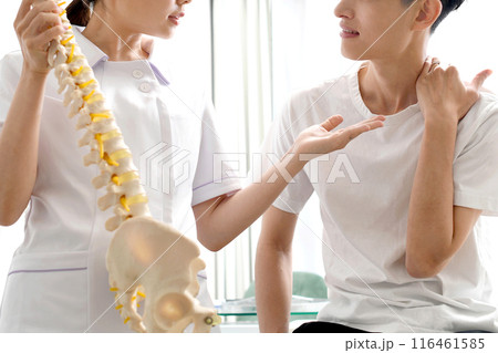 骨の模型を使い男性患者に説明する女性医師 骨の模型を使い男性患者に説明する女性医師 116461585