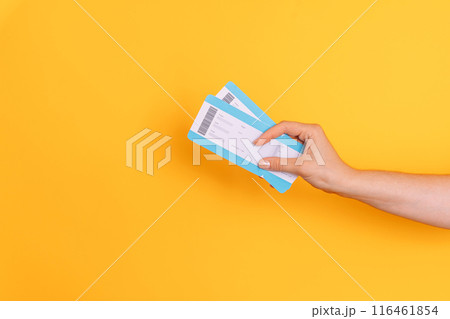 Hand holding tickets against yellow background 116461854