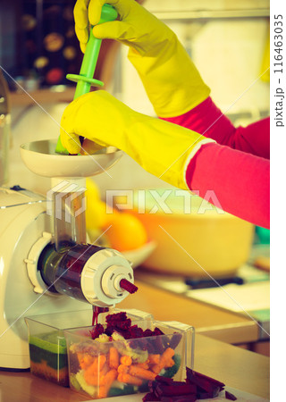 Woman make vegetables juice in juicer machine Woman make vegetables juice in juicer machine 116463035