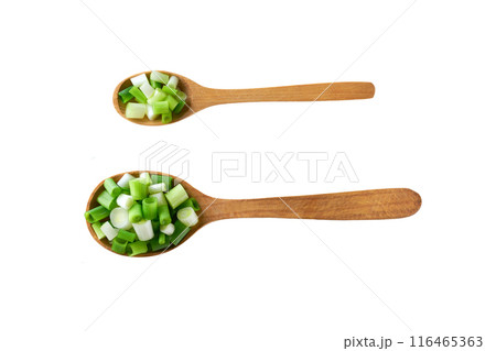 Chopped spring onions in a wooden spoon isolated on white background. Top view. 116465363