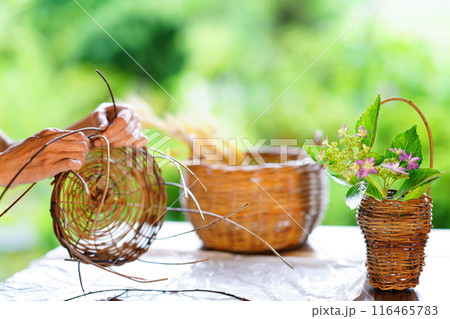 籠を編む女性の手元と手作りの籠 116465783