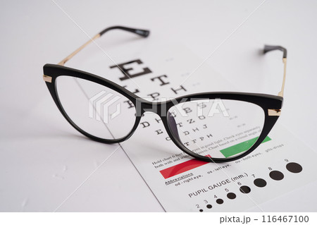 Glasses on eye exam chart to test eyesight accuracy of reading. Glasses on eye exam chart to test eyesight accuracy of reading. 116467100