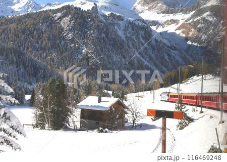 山の中の一軒家の脇を赤い列車が走ります。 116469248