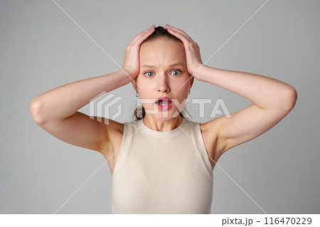 Startled Woman With Surprised Expression on gray background Startled Woman With Surprised Expression on gray background 116470229