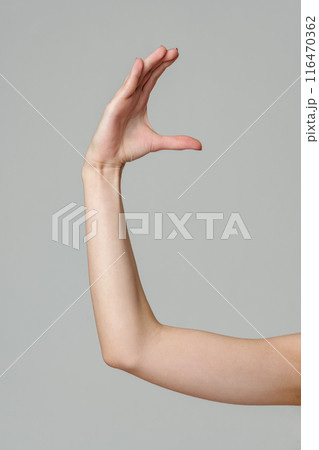 Female hand sign against gray background in studio 116470362