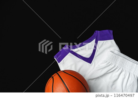 Close-Up of Basketball and White and Purple Jersey on a Black Background 116470497