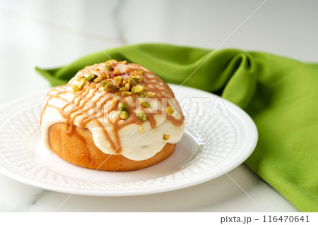 Cinnamon roll bun with icing on plate 116470641