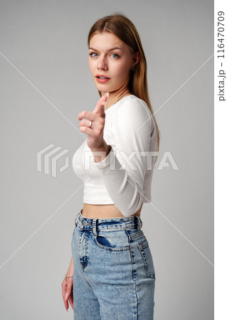 Smiling Young Woman With Braces Pointing Towards Camera in Studio Smiling Young Woman With Braces Pointing Towards Camera in Studio 116470709