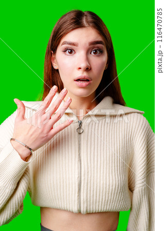 A woman wearing a white sweater is gesturing with her hand, possibly expressing emotion or emphasizing a point. A woman wearing a white sweater is gesturing with her hand, possibly expressing emotion or emphasizing a point. 116470785