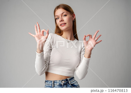 Young Woman Giving Thumbs Up Sign in studio Young Woman Giving Thumbs Up Sign in studio 116470813