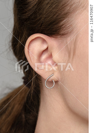 Female ear with earring and hair in ponytail close up Female ear with earring and hair in ponytail close up 116470907