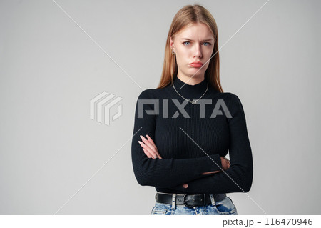 Young Woman Wearing Black Top and Jeans against gray background 116470946