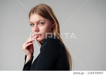Young Woman In Black Shirt Expressing Discontent Against Grey Background Young Woman In Black Shirt Expressing Discontent Against Grey Background 116470947