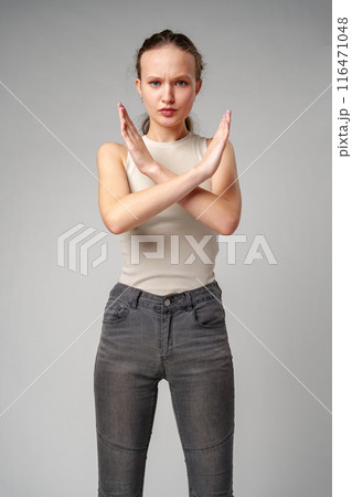 Young Woman Making Stop Sign With Hands on gray background Young Woman Making Stop Sign With Hands on gray background 116471048