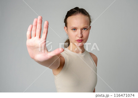 Young Woman Making Stop Sign With Hands on gray background 116471074