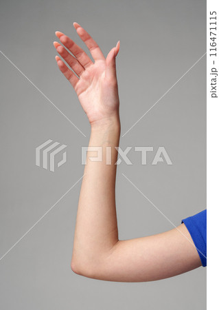 Female hand sign against gray background in studio 116471115