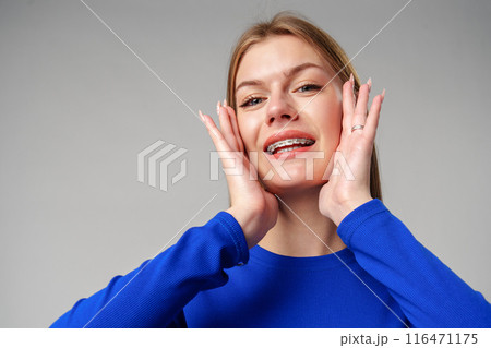 Young Woman Expressing Surprise or Confusion Against a Grey Background Young Woman Expressing Surprise or Confusion Against a Grey Background 116471175