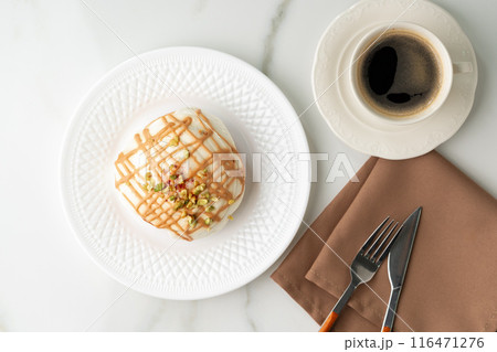 Cinnamon roll bun with icing on plate 116471276