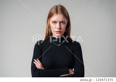 Young Woman Wearing Black Top and Jeans against gray background Young Woman Wearing Black Top and Jeans against gray background 116471335