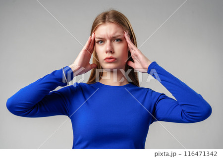 Woman in Blue Top Holding Hands to Ears in studio Woman in Blue Top Holding Hands to Ears in studio 116471342