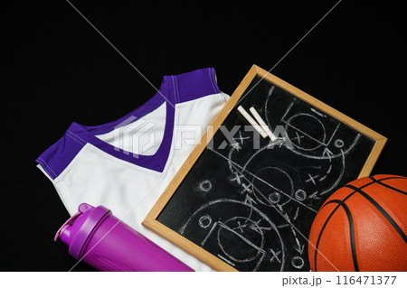 Basketball Strategy Planning With Chalkboard, Ball, and Jersey on Dark Background Basketball Strategy Planning With Chalkboard, Ball, and Jersey on Dark Background 116471377
