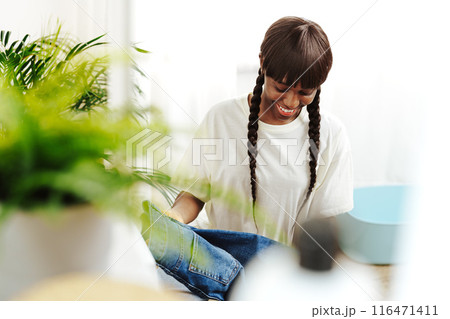 African Woman Folding Laundry After Washing Clothes in Modern Laundry Room 116471411