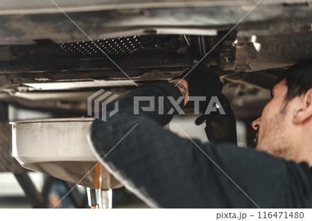 Car mechanic changing oil in a car service 116471480