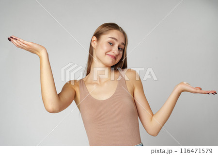 Clueless Young Woman Holding Out Her Hands Gesturing She Doesn't Know 116471579