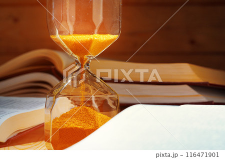 Golden sand hourglass close up on working table Golden sand hourglass close up on working table 116471901
