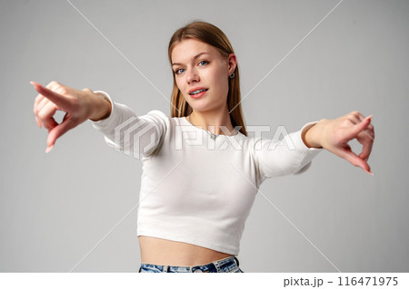 Smiling Young Woman With Braces Pointing Towards Camera in Studio Smiling Young Woman With Braces Pointing Towards Camera in Studio 116471975