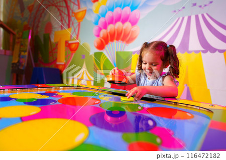 Young Girl Engaging in Colorful Board Game Fun at a Vibrant Playroom 116472182