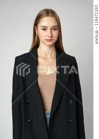 Young Woman in Black Jacket Posing to Camera against gray background 116472265