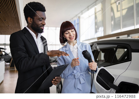 Dealer sells electric SUV to business woman at dealership Dealer sells electric SUV to business woman at dealership 116472988