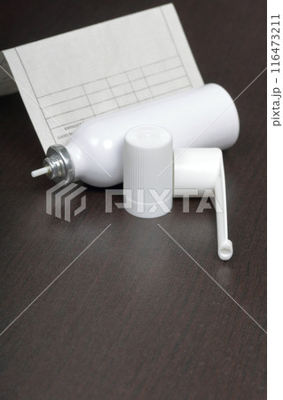 Inhaler for the treatment of respiratory organs. Spray can and cap white. Next recipe to buy. On a dark surface. Inhaler for the treatment of respiratory organs. Spray can and cap white. Next recipe to buy. On a dark surface. 116473211