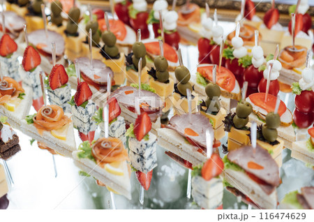 A large selection of various snacks for guests on a mirror surface. Buffet before an important event 116474629