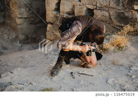 An archaeologist takes a photo of a found artifact 116475019