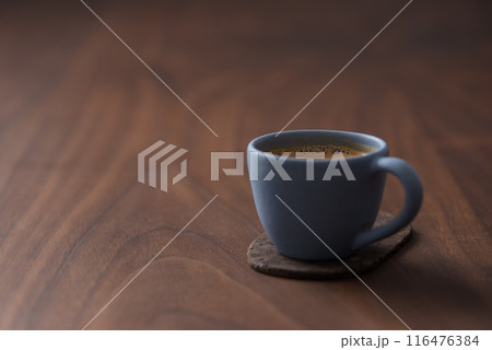 Fresh espresso in a blue cup on walnut table with copy space 116476384