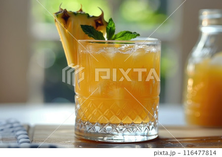 A refreshing pineapple cocktail in a glass with a piece of pineapple 116477814