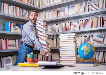 Teachers day. Teacher in school classroom. teacher with book in library classroom. Hispanic teacher in college. Man with books in library. Knowledge and education concept. school library. Book lover Teachers day. Teacher in school classroom. teacher with book in library classroom. Hispanic teacher in college. Man with books in library. Knowledge and education concept. school library. Book lover 116478727