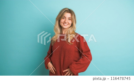 Happy woman laughing at camera in blue studio Happy woman laughing at camera in blue studio 116478745