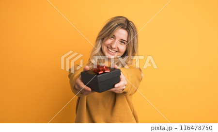 Happy young woman receiving gift box and saying thanks on yellow background Happy young woman receiving gift box and saying thanks on yellow background 116478750