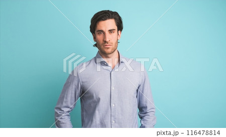 Serious man looking at camera in blue studio Serious man looking at camera in blue studio 116478814