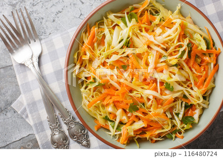 Lahanosalata Greek Cabbage Salad Vinegar Coleslaw with carrot and parsley seasoned with olive oil closeup on the bowl. Horizontal top view 116480724