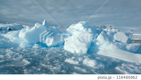 Close up snow-covered ice on frozen ocean surface in Antarctica. Mountains in background. Cold winter wild nature landscape. Discover beauty of South Pole. Antarctic travel and exploration panorama Close up snow-covered ice on frozen ocean surface in Antarctica. Mountains in background. Cold winter wild nature landscape. Discover beauty of South Pole. Antarctic travel and exploration panorama 116480862