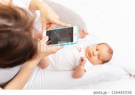 Mom Taking Photo of Newborn Baby with Smartphone.. 116483550