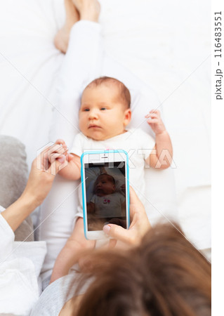 Mom Taking Photo of Newborn Baby with Smartphone.. Mom Taking Photo of Newborn Baby with Smartphone.. 116483551