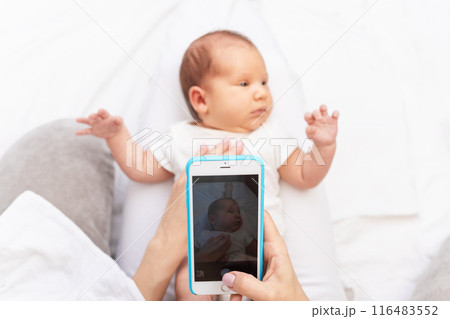 Mom Taking Photo of Newborn Baby with Smartphone.. 116483552