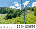 Cable car seats soar over beautiful mountains on a sunny day in Krasnaya Polyana 116483656