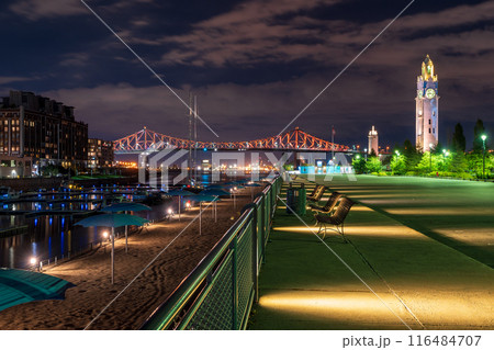 Old Port of Montreal Clock Tower and Jacques Cartier Bridge illuminated at night. Montreal, Quebec, Canada. 116484707