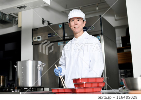 弁当箱に料理を詰める男性の調理スタッフ 116485029